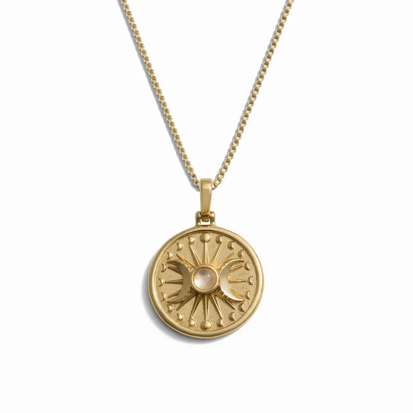 Gold-toned necklace with a circular pendant featuring a triple moon design and a central stone.