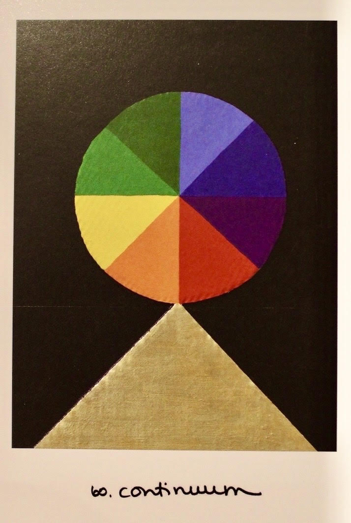 A colorful eight-segment color wheel balanced on a golden triangle.