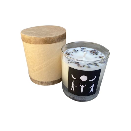 Lavender scented candle with black and white design featuring phases of the moon and figures, housed in a clear glass jar.