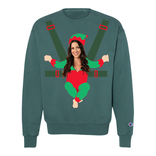 Teal sweatshirt featuring a humorous Christmas elf design with a woman’s face and upper body incorporated.